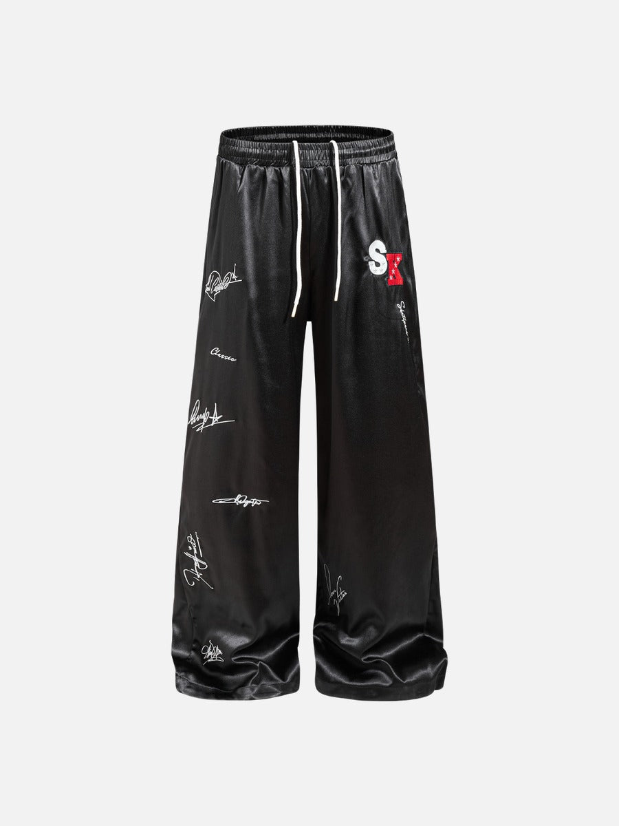 DAXUEN black satin wide-leg pants with bold two-letter graphic