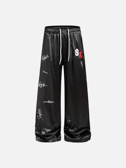 DAXUEN black satin wide-leg pants with bold two-letter graphic