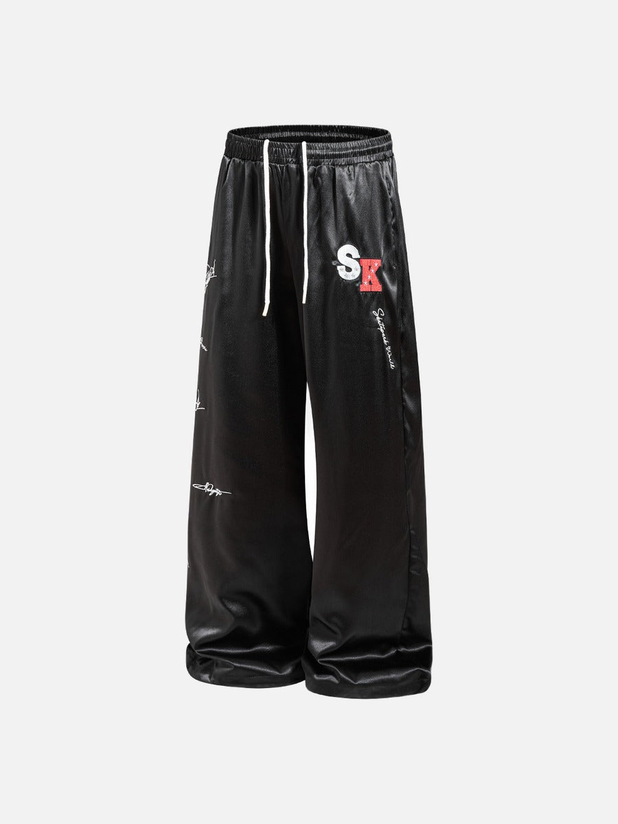 DAXUEN black satin wide-leg pants with bold two-letter graphic
