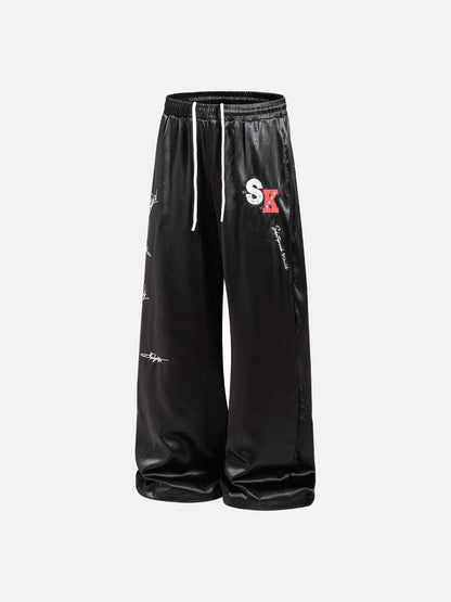 DAXUEN black satin wide-leg pants with bold two-letter graphic