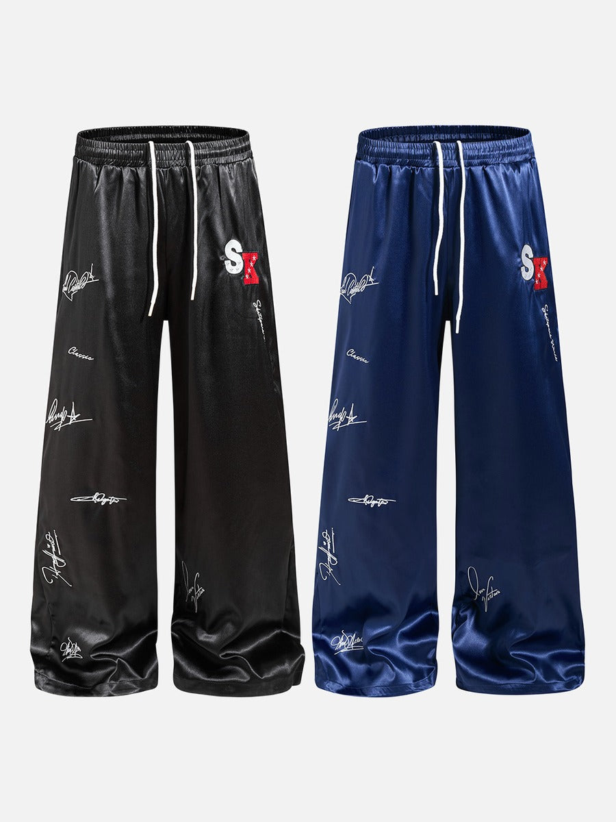 DAXUEN black satin wide-leg pants with bold two-letter graphic