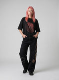 DAXUEN black oversized circular red text graphic tee — model photo