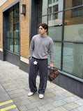 DAXUEN Wide leg sweatpants with cross print and script embroidery — model photo