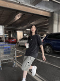 DAXUEN washed black oversized curved-seam emblem tee — model photo