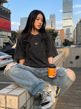 DAXUEN washed black oversized curved-seam emblem tee — model photo