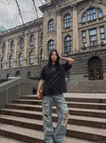 DAXUEN washed black oversized curved-seam emblem tee — model photo