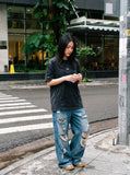 DAXUEN washed black oversized curved-seam emblem tee — model photo