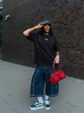 DAXUEN Distinctive short-sleeved T-shirt with emblem and pleated panels — model photo