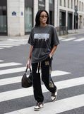 DAXUEN dark olive oversized silhouetted crowd graphic t-shirt — model photo