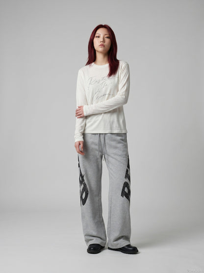 DAXUEN Distressed script long sleeve t-shirt in beige and grey — model photo
