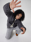 DAXUEN grey and black wide-leg sweatpants with bold cross graphic — model photo