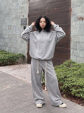 DAXUEN grey and black wide-leg sweatpants with bold cross graphic — model photo