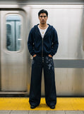 DAXUEN dark indigo wide-leg gothic graphic denim pants — model photo
