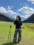 DAXUEN black polo shirt with leopard print collar and cross graphic — model photo
