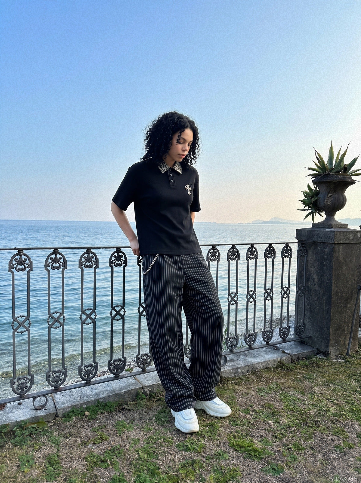DAXUEN black polo shirt with leopard print collar and cross graphic — model photo