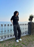 DAXUEN black polo shirt with leopard print collar and cross graphic — model photo