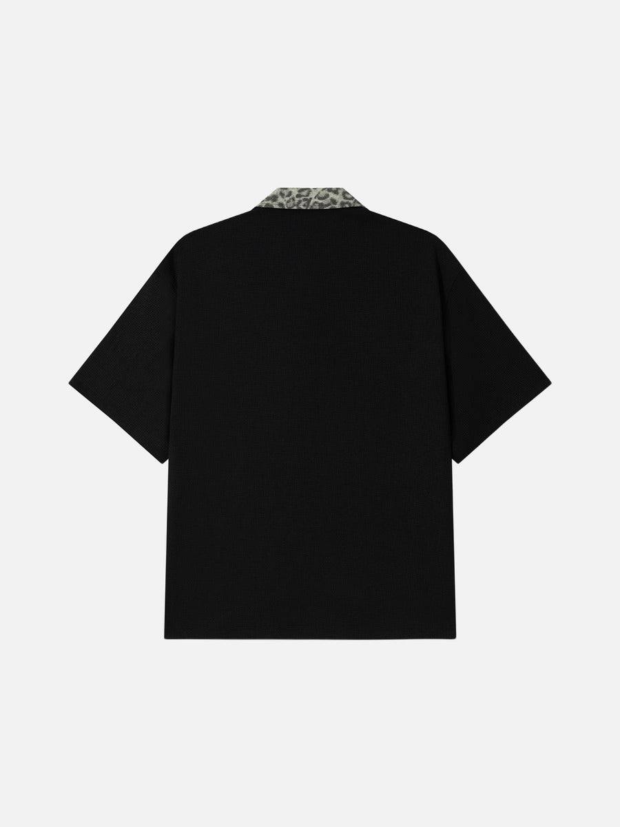 DAXUEN black polo shirt with leopard print collar and cross graphic