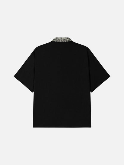 DAXUEN black polo shirt with leopard print collar and cross graphic