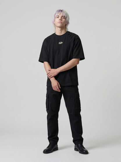 DAXUEN Short-sleeved T-shirt with metallic emblem and pleated details — model photo
