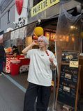 DAXUEN Short-sleeved T-shirt with metallic emblem and pleated details — model photo