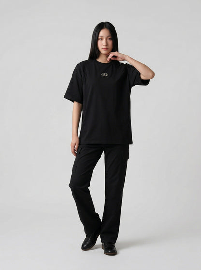 DAXUEN Short-sleeved T-shirt with metallic emblem and pleated details — model photo