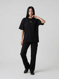 DAXUEN Short-sleeved T-shirt with metallic emblem and pleated details — model photo