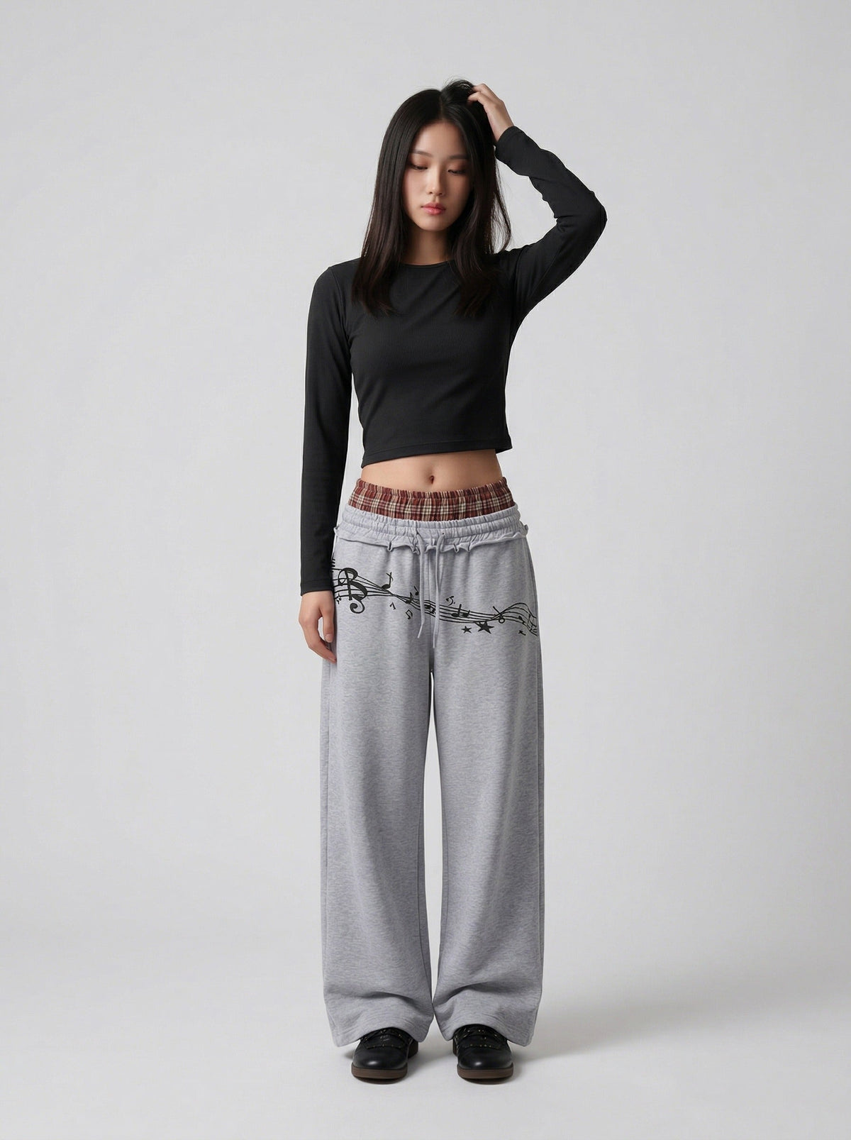 DAXUEN Grey wide-leg sweatpants with musical print and plaid details — model photo