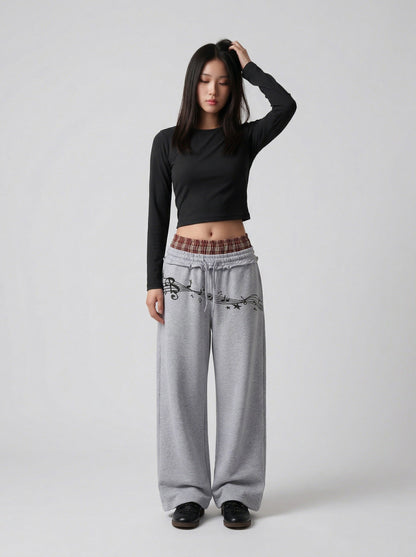 DAXUEN Grey wide-leg sweatpants with musical print and plaid details — model photo