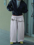 DAXUEN Grey wide-leg sweatpants with musical print and plaid details — model photo