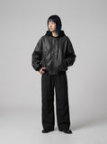 DAXUEN Oversized hooded bomber jacket in black faux leather — model photo