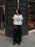 DAXUEN light blue and white striped playful graphic polo top — model photo