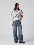 DAXUEN light blue and white striped playful graphic polo top — model photo