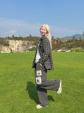 DAXUEN striped wide-leg pants with skull and structure patches — model photo