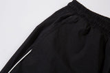 DAXUEN black track pants with stylized oval graphic
