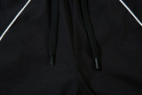 DAXUEN black track pants with stylized oval graphic
