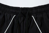 DAXUEN black track pants with stylized oval graphic