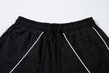 DAXUEN black track pants with stylized oval graphic