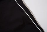 DAXUEN black track pants with stylized oval graphic