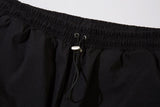 DAXUEN black track pants with stylized oval graphic