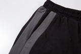 DAXUEN black track pants with stylized oval graphic