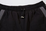 DAXUEN black track pants with stylized oval graphic