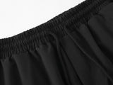 DAXUEN black track pants with stylized oval graphic