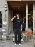 DAXUEN solid color oversized t-shirt with stylized wordmark graphic — model photo