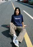 DAXUEN solid color oversized t-shirt with stylized wordmark graphic — model photo