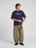 DAXUEN solid color oversized t-shirt with stylized wordmark graphic — model photo
