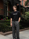 DAXUEN solid color oversized t-shirt with stylized wordmark graphic — model photo