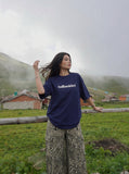 DAXUEN solid color oversized t-shirt with stylized wordmark graphic — model photo