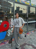 DAXUEN Oversized graphic T-shirt with human figures and text — model photo