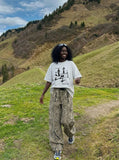 DAXUEN Oversized graphic T-shirt with human figures and text — model photo