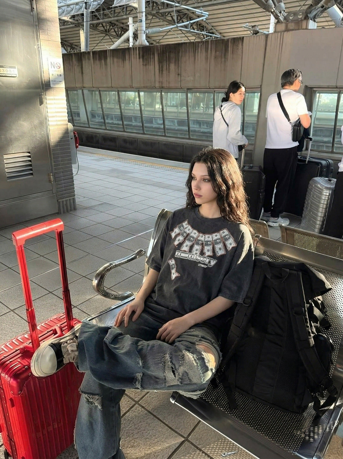 DAXUEN Washed oversized graphic t-shirt with dollar bills and 'misery' print — model photo